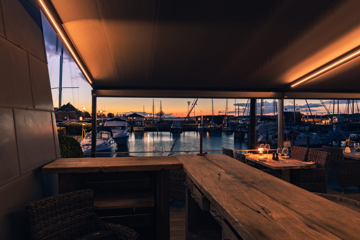 Restaurant Suri i Holbæk – aften med oplyst markise og solnedgang over havnen (foto 1)