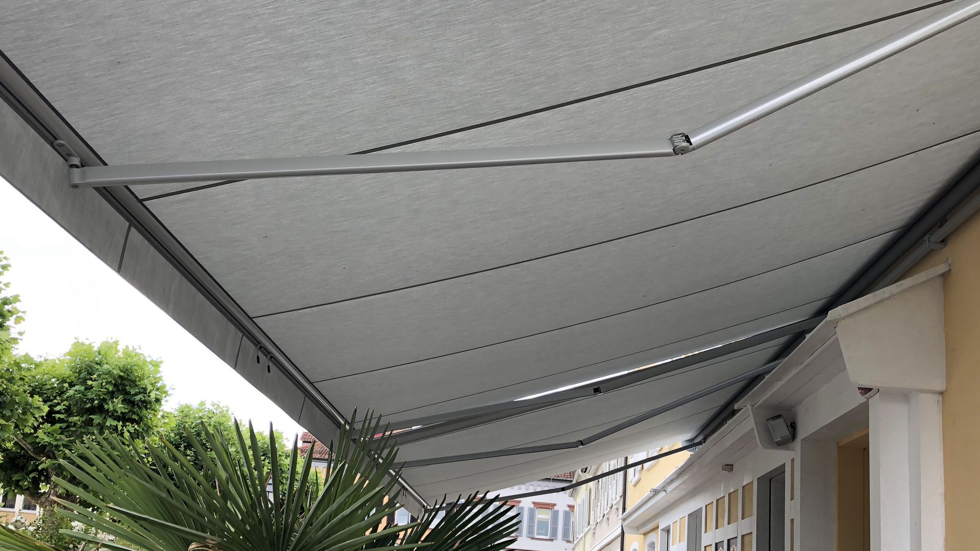 Markilux 1300 markise set nedefra på en gul husmur