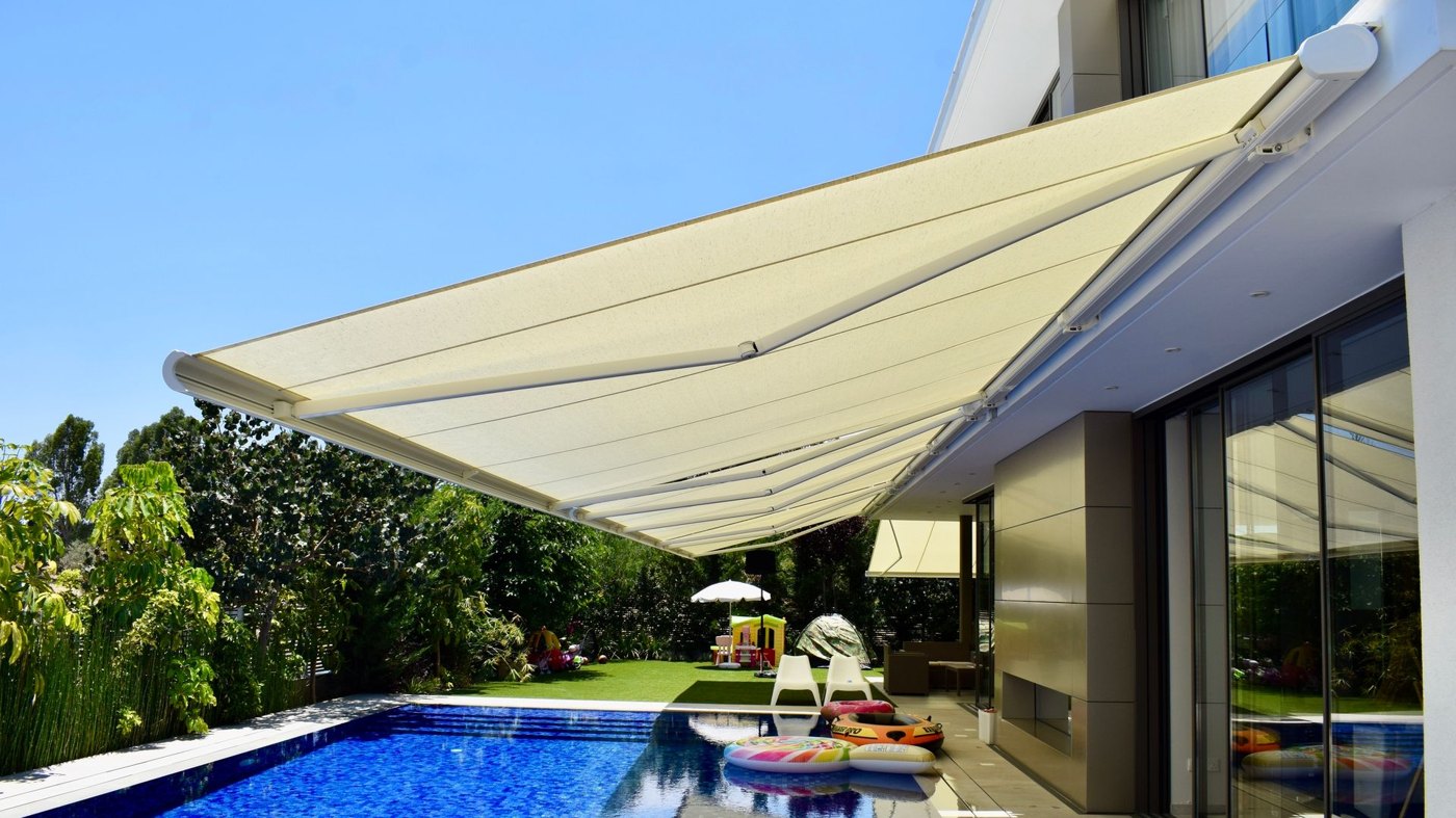 Markilux 5010 helkassettemarkise med hvid dug over terrassen på et moderne hus med pool