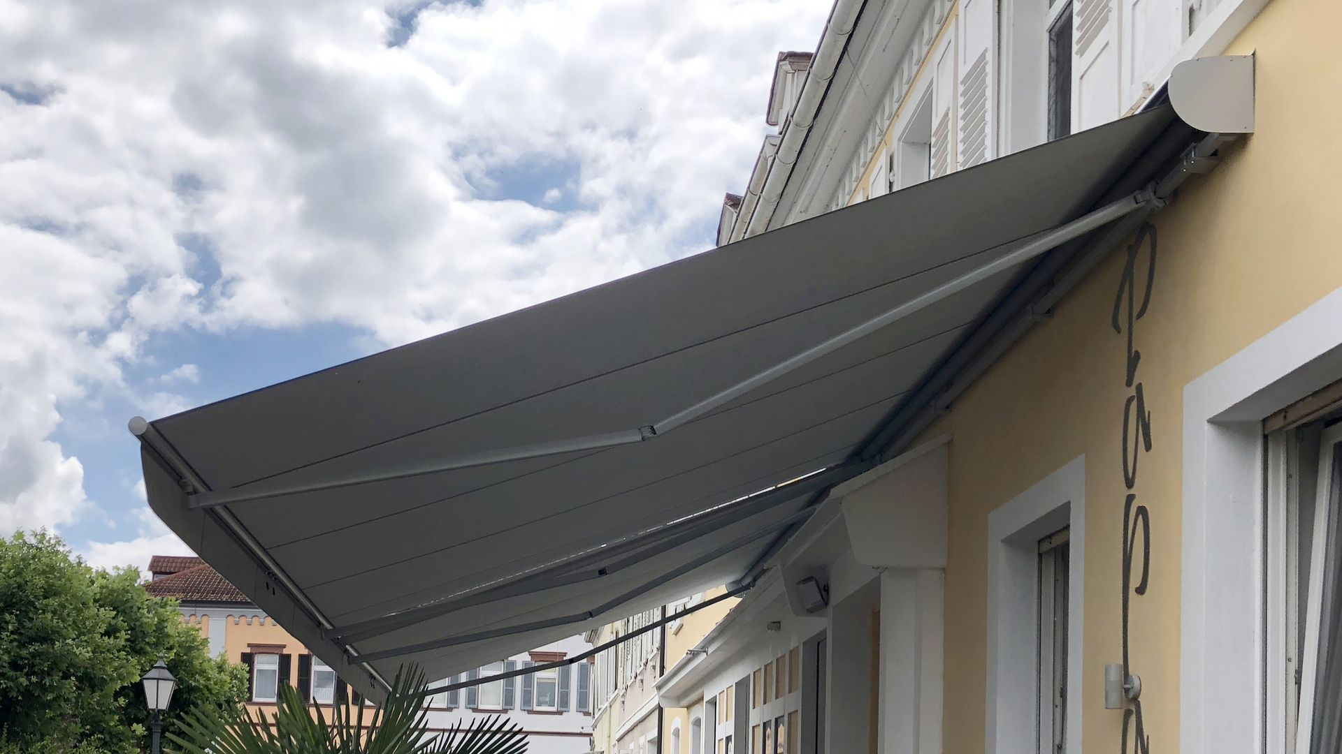 Markilux 1300 markise monteret på en gul husmur